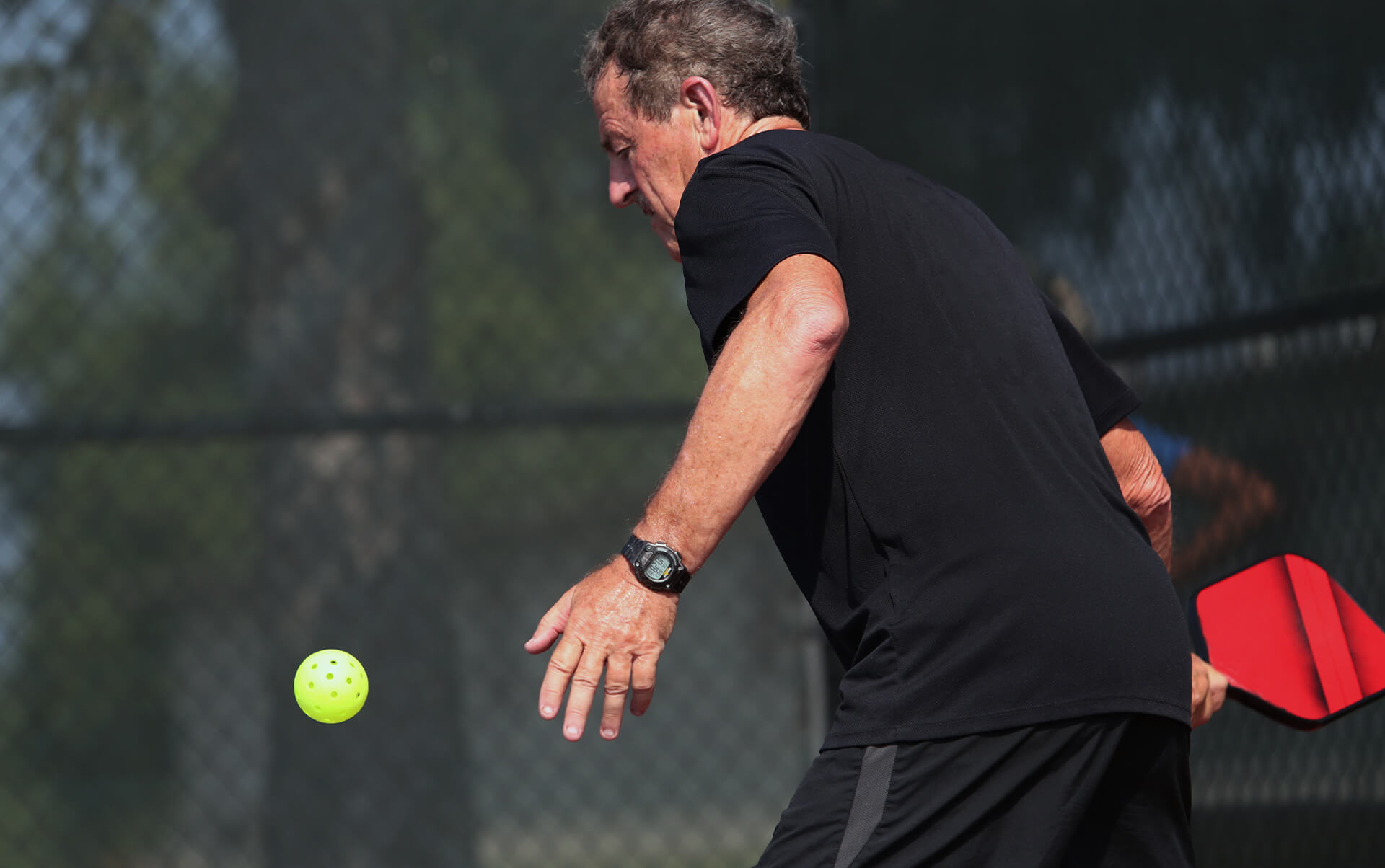 An active senior man playing pickleball
