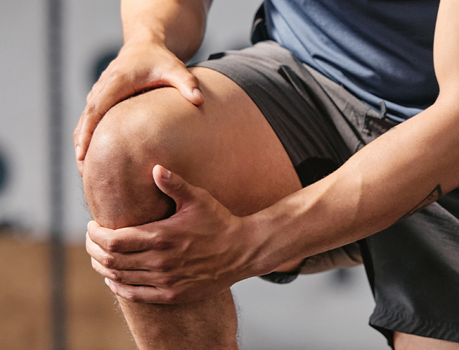 A man holding his aching knee