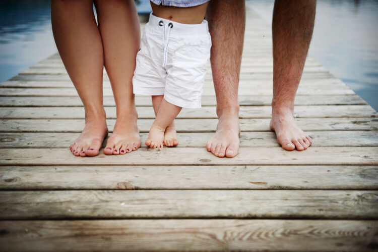 Legs and feet of a family of three.