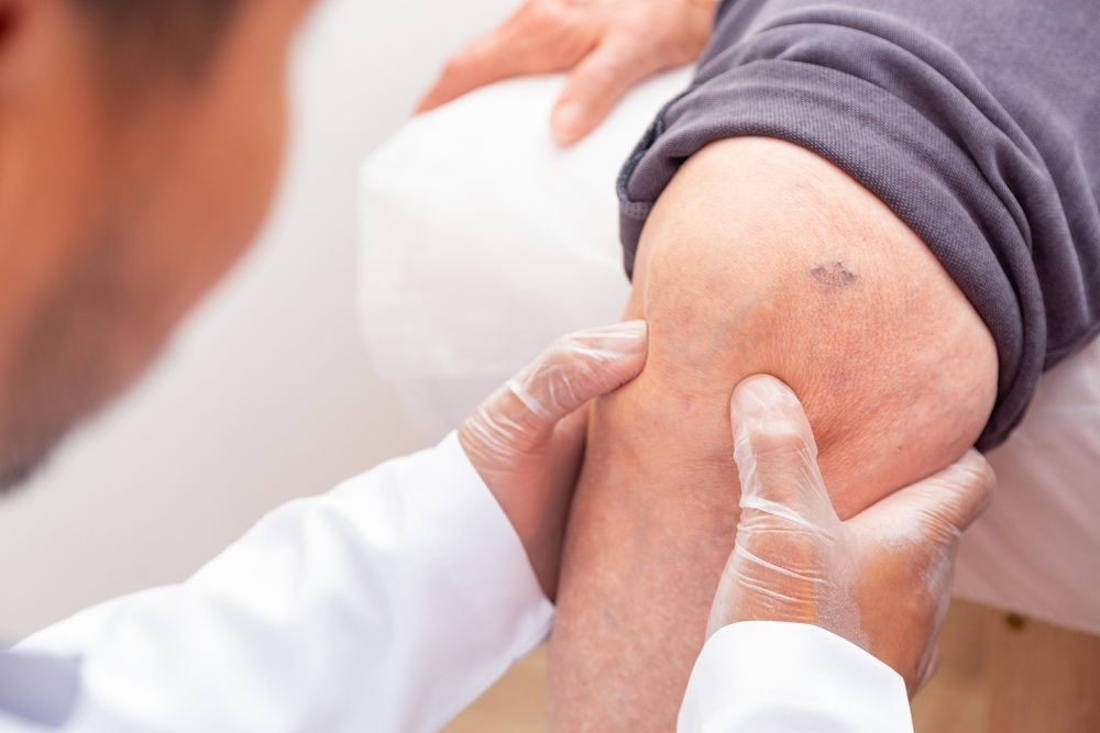 A doctor examining a patient's knee.