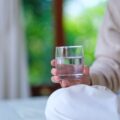 A woman's hand holding a cup of water.