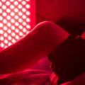 A man using red light therapy on his leg.