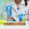 A woman in a lab coat with the word "Peptides" in block letters.